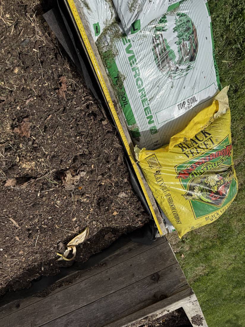 Bags of soil and mulch staged for the raised beds